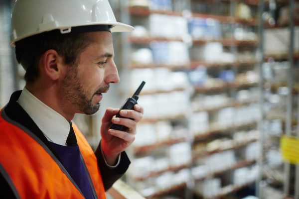 Speaking to staff Master in uniform and helmet speaking by walkie-talkie